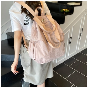 Detail of light pink waterproof travel backpack with side pockets and fabric straps