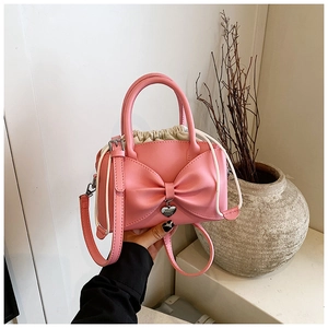Vue détaillée du sac seau rose avec nœud, pendentif cœur et doublure à cordon