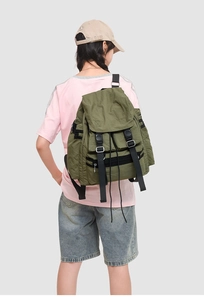 Vue arrière du modèle portant un sac à dos en nylon vert armée avec fermeture à rabat