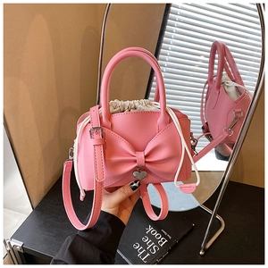 Vue détaillée du sac seau rose à nœud avec pendentif cœur et doublure à cordon