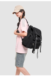 Vue latérale du sac à dos en nylon noir avec cordon de serrage et poches zippées pratiques