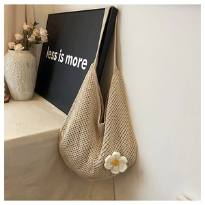 Gros plan détaillé d'un sac cabas en maille tressée orné de marguerites 3D blanches