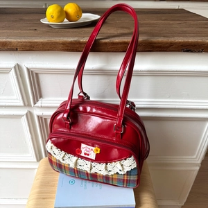 Detail of red leather tote bag with plaid base, lace trim and sweet cherry embroidery