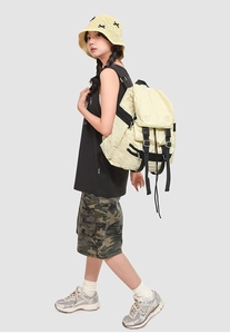 Sac à dos grande capacité jaune crème avec boucles noires présenté en situation extérieure