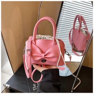 Détail du sac seau rose avec nœud papillon, pendentif cœur et doublure amovible