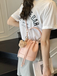Pink lychee grain leather bucket bag with drawstring closure and cute bear charm