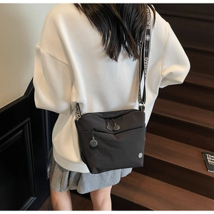 Detail of black nylon crossbody bag with adjustable S.CHAO logo wide strap on model