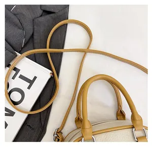 Detail of lychee textured leather bag with beige body and yellow shoulder strap