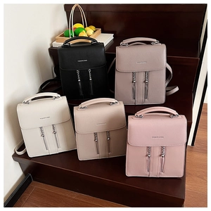 Five minimalist mini backpacks in black, grey, white, apricot and pink on steps