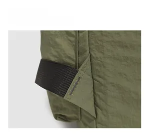 Détail macro des coutures renforcées et du tissu ripstop durable du sac à dos vert