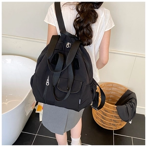 Detail of black multi-pocket travel backpack showing durable nylon and zipper layers