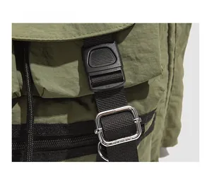 Détail de la boucle en plastique noir et du réglage en métal sur le sac vert olive