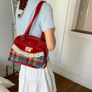 Detail of red patent PU tote bag with plaid patchwork and sweet cherry label design
