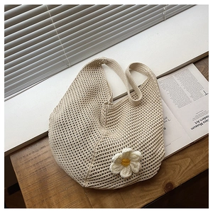 Détail d'un sac cabas en crochet crème orné d'une petite fleur de marguerite décorative