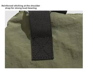 Détail de la couture en croix en X renforcée sur la bandoulière du sac en nylon robuste