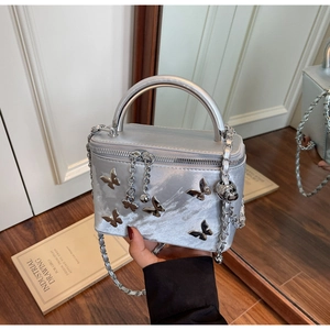 Detailed macro shot of silver bow box bag showing metallic hardware and silk texture