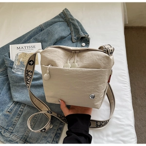Detail of off-white canvas crossbody bag with jacquard SJCHA logo wide shoulder strap