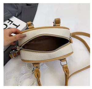Detail view of the spacious inner compartment and lychee grain texture on this Boston bag