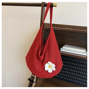 Gros plan détaillé d'un sac cabas rouge en tricot avec fleur de marguerite blanche