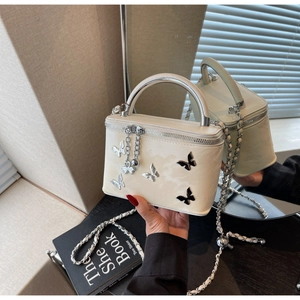 Detail of cream white vanity case with silver metal handle and 3D butterfly ornaments