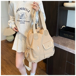 Close-up of beige multifunctional nylon tote bag with adjustable shoulder straps and side pockets