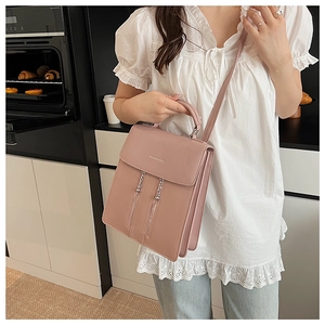 Détail du sac multi-usage en cuir rose avec texte fashion et double fermeture éclair