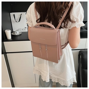 Détail du sac à dos en cuir rose avec pompons en chaîne et bretelles réglables