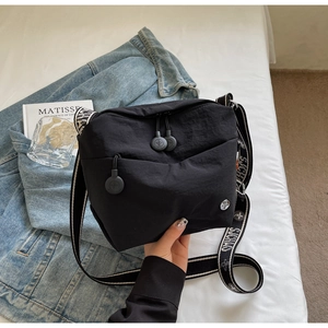 Detail of black nylon crossbody bag with striped jacquard wide strap and logo zipper
