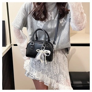 Litchi pattern black Boston bag featuring pearl lace bow charm and crossbody strap