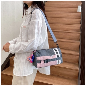 Détail de sac bandoulière en nylon à carreaux avec pompon perlé et boucle latérale