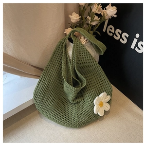 Détail du sac fourre-tout en crochet vert avec fleur de marguerite blanche et texture