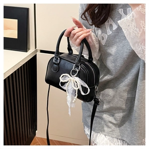 Litchi texture black Boston bag featuring white lace bow and pearl charm detail
