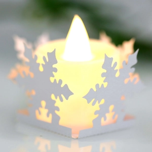 Detailed view of white snowflake cut-out paper lampshade with warm yellow LED tea light