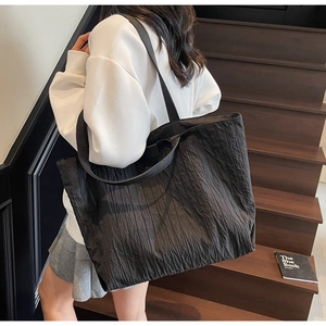 Detail of black pleated texture tote bag showing its unique fabric and large capacity