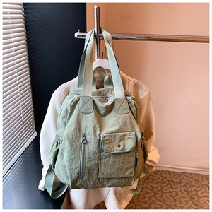 Detail view of sage green multi-functional lightweight backpack with dual zip compartments