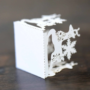 Detailed laser-cut deer and snowflake patterns on a white Christmas paper lantern shade