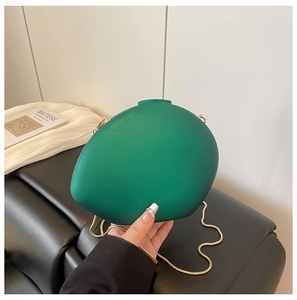 Détail d'un sac de soirée vert émeraude avec chaîne serpent dorée et livre d'art Matisse
