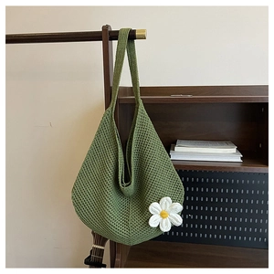 Détail du sac hobo tissé main vert avec une grande fleur de marguerite blanche tricotée