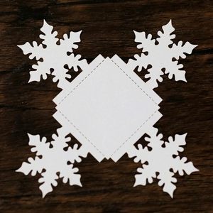 Detailed laser-cut white paper snowflake decoration with intricate hollow patterns