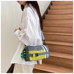 Détail du sac polochon en nylon à carreaux avec touches néon et rayures de course