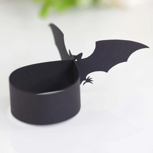 Close-up of black paper Halloween bat napkin ring with intricate cutout bat wing details