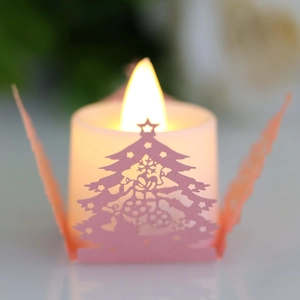 Bougie LED avec abat-jour en papier rose découpé sapin de Noël créant une lueur chaleureuse