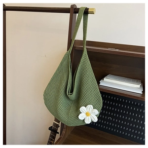 Détail du sac cabas tressé vert avec une fleur de marguerite en relief crochetée main