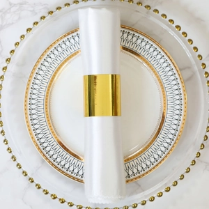 Macro view of golden napkin ring on white marble surface with luxury tableware