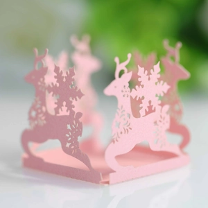 Detailed laser-cut pink paper candy box with intricate reindeer and snowflake patterns