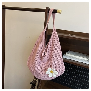 Gros plan détaillé d'un sac cabas en crochet rose avec une fleur de marguerite blanche