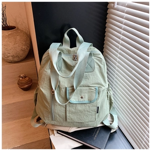 Detail view of mint green nylon backpack with side water bottle pocket and side buckle closure
