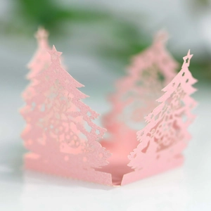 Close-up of pink laser-cut Christmas tree candy box with intricate snowflake patterns