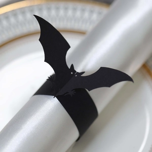 Detailed view of a black bat napkin ring on a silk napkin for Halloween table decor