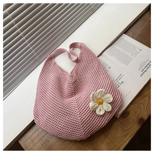 Détail du sac fourre-tout en crochet rose fait main avec marguerite blanche sur table